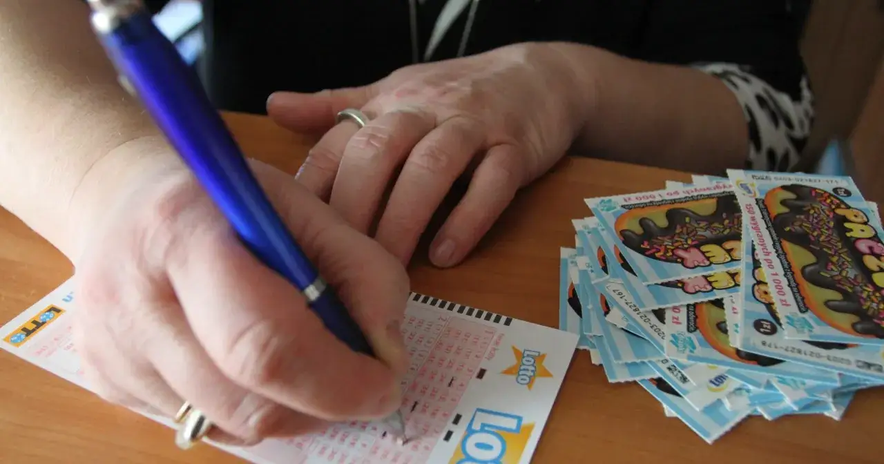 Ręka z długopisem zaznacza liczby na kuponie Lotto. Obok stos zdrapek. Jak chronić swoją anonimowość po wygraniu milionów w krajowej loterii?