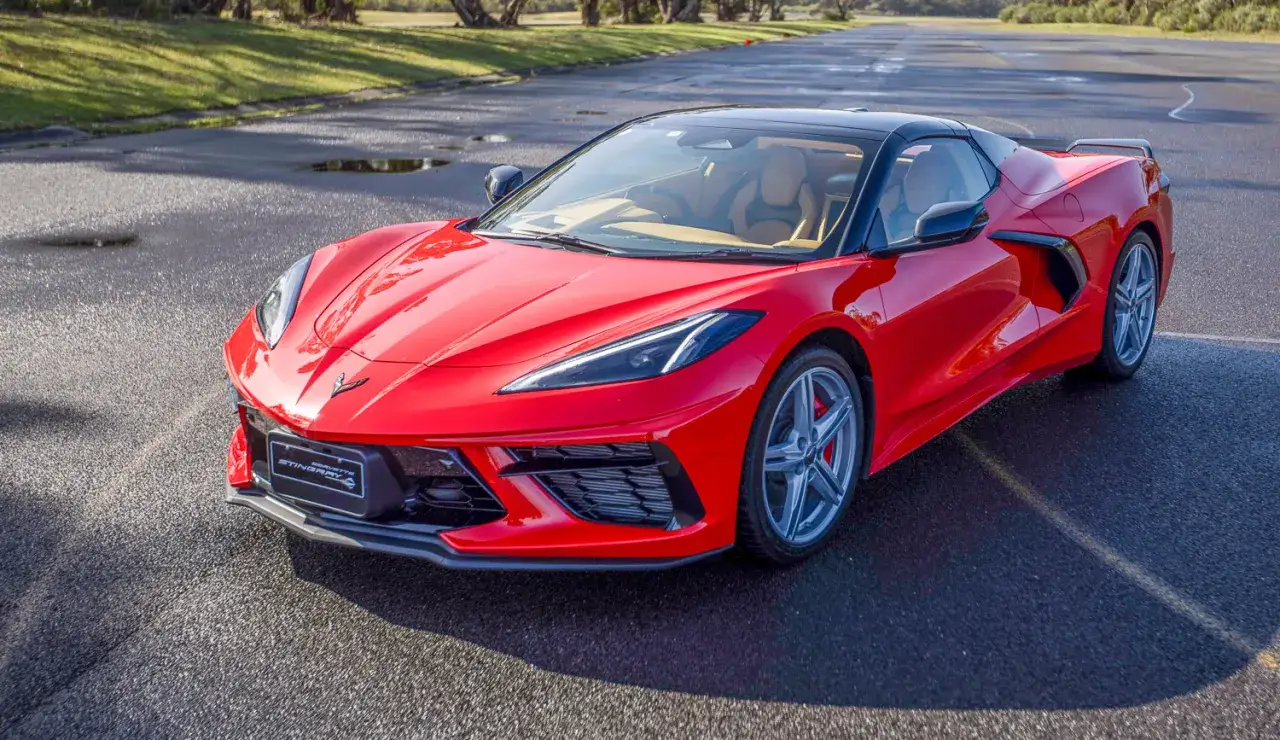 Czerwony Chevrolet Corvette C8 Stingray na mokrej nawierzchni. Marzysz o tym aucie? Sprawdź corvette c8 cena i spełnij marzenie.