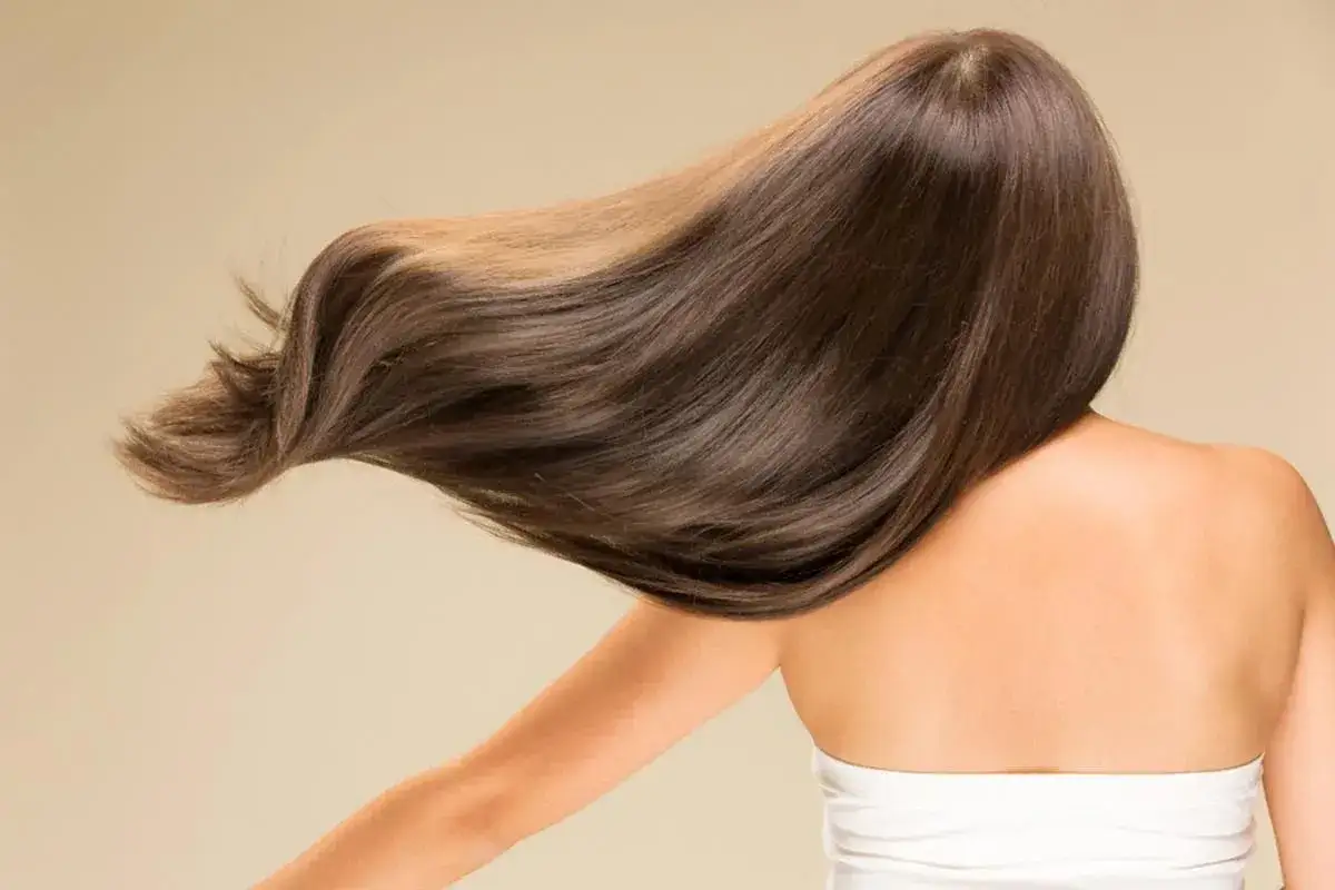 Cabello casta&ntilde;o largo y sedoso movi&eacute;ndose. Descubre c&oacute;mo secar el pelo sin secador para un brillo natural.