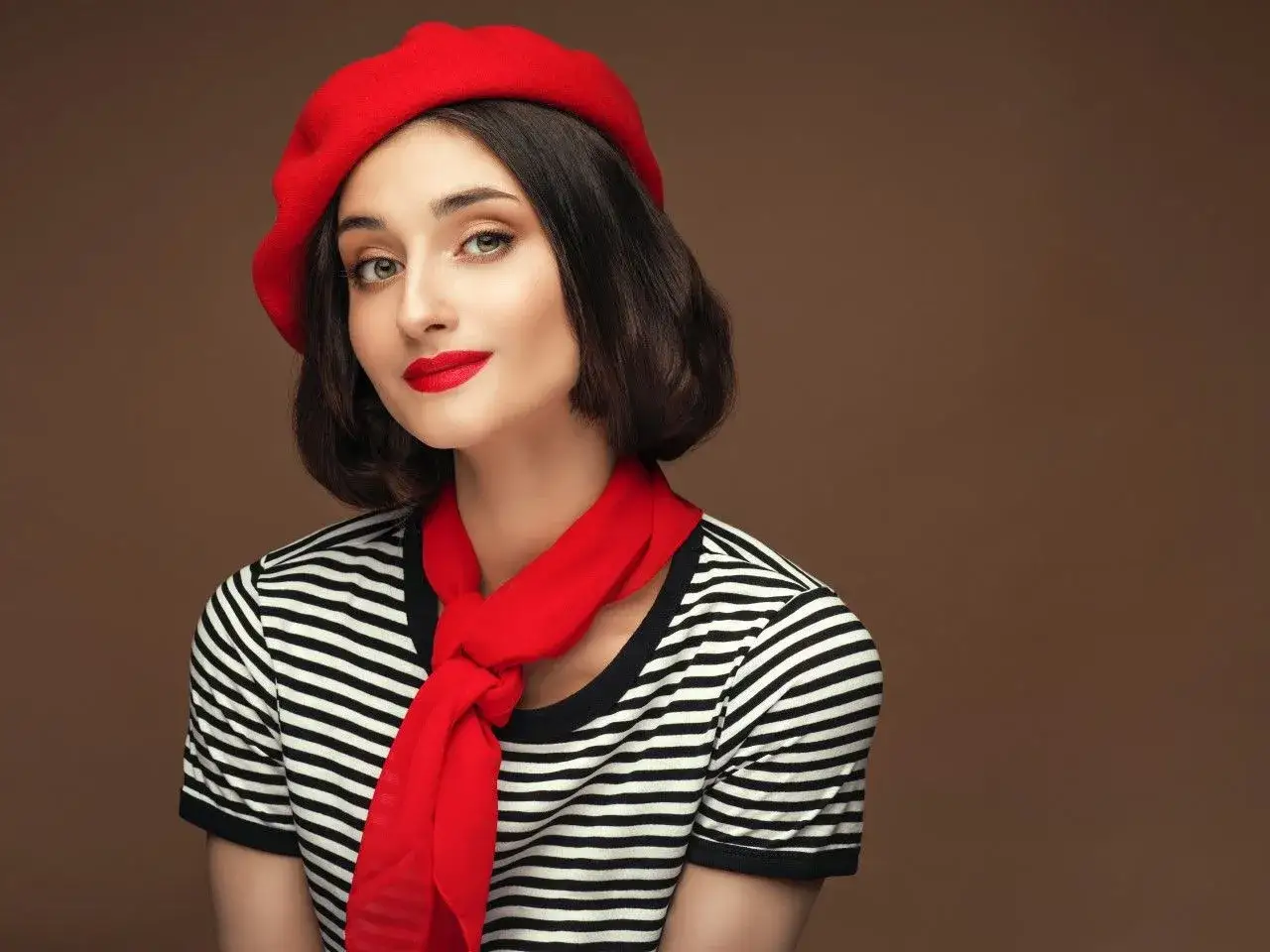Elegancki beret damski w stylizacjach. Czerwony beret, szalik i makijaż podkreślają francuski szyk.