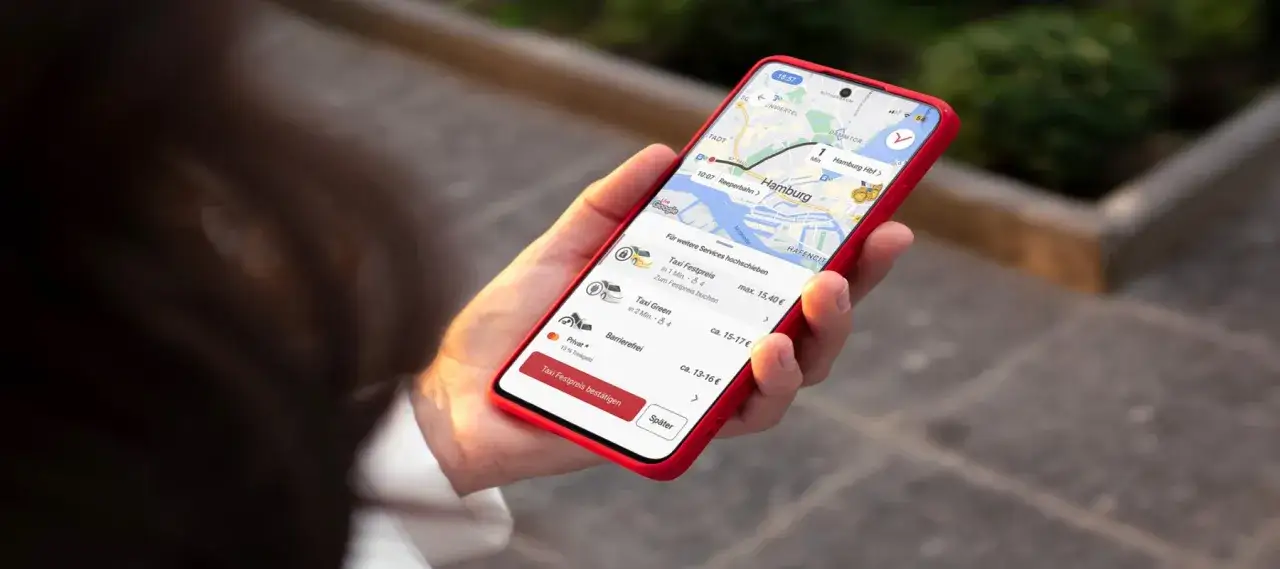 Smartphone zeigt Taxi-App mit Hamburg-Karte und verschiedenen Taxi-Optionen. Hier siehst du die free now taxi preise f&uuml;r deine Fahrt.