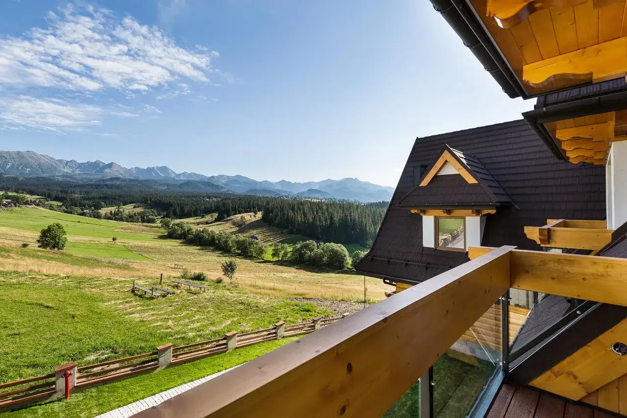 Widok z tarasu hotelu Kopieniec Murzasichle na zielone wzgórza i Tatry.