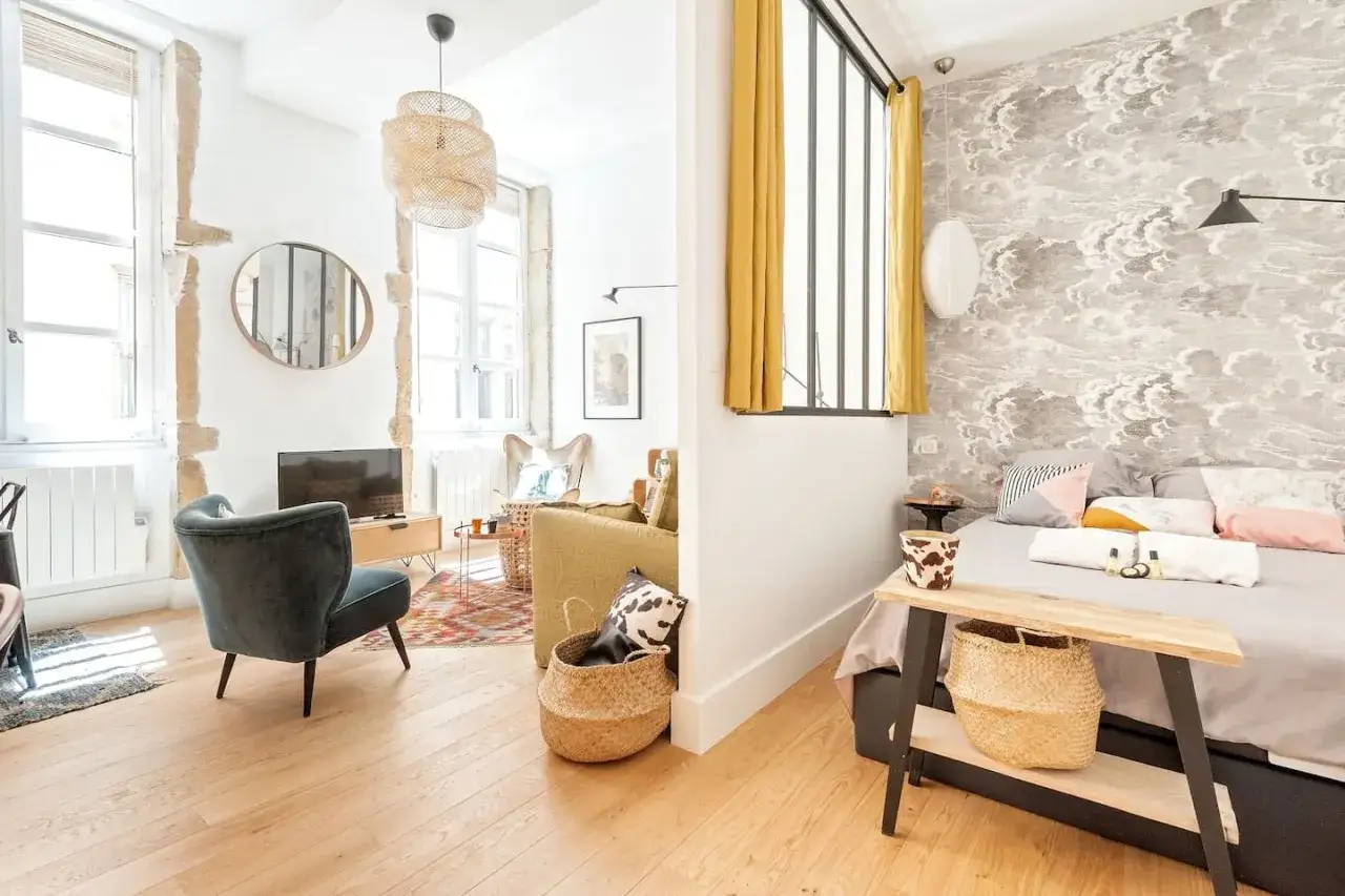 Une belle idée séparation chambre salon avec un mur décoré de nuages et des rideaux jaunes.