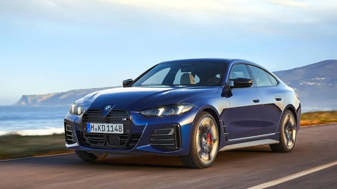 Eleganckie, granatowe BMW Gran Coupé pędzi po malowniczej drodze nad morzem.