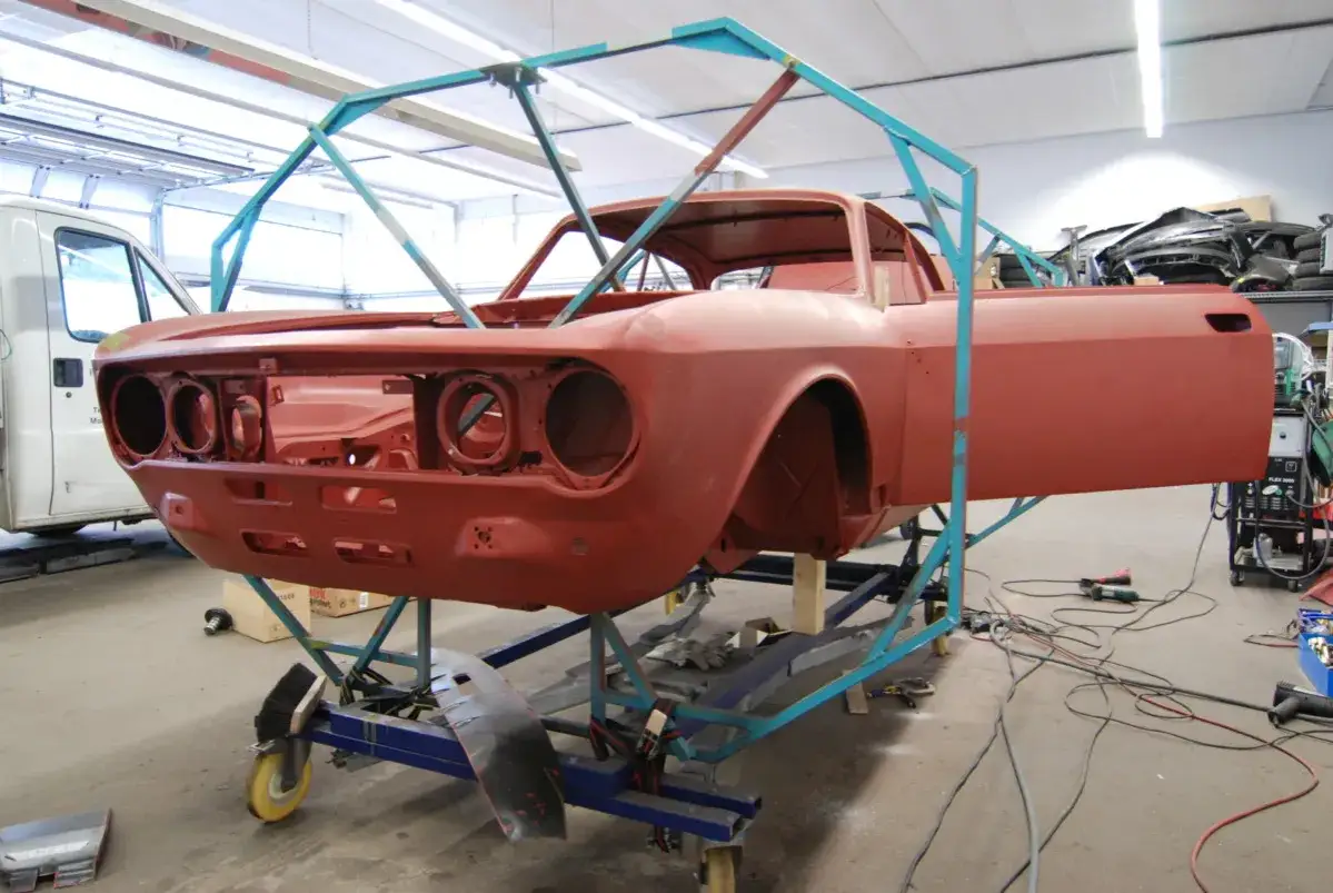 Roter Oldtimer im Lackierprozess, bereit f&uuml;r neue Farbe. Die **Oldtimer Lackieren Kosten** h&auml;ngen vom Aufwand ab.