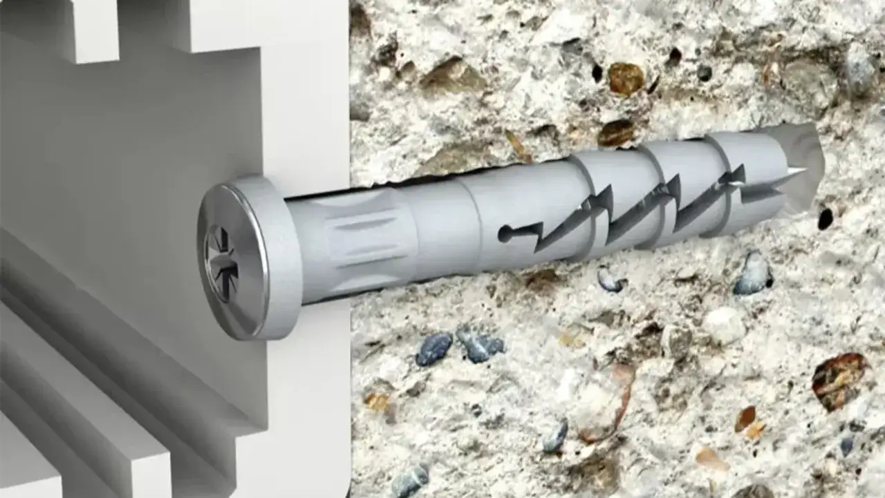 Kołki do wełny mineralnej wkręcone w beton. Widoczny metalowy łebek i szary kołek z ząbkami.