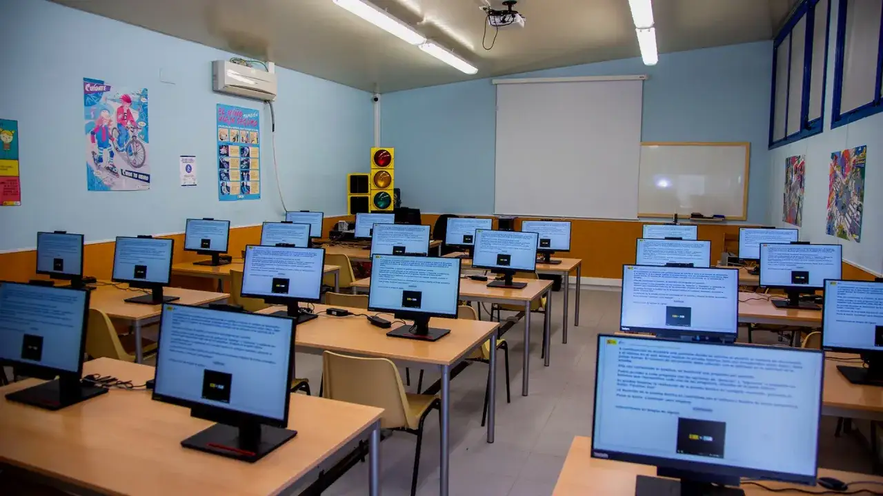 Aula de informática con ordenadores listos para el examen teórico. ¡Imagina la satisfacción si apruebas el teórico a la primera!