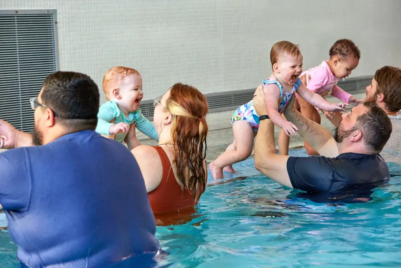 Parents and babies enjoy baby and me swim classes, with happy giggles and splashing in the pool.