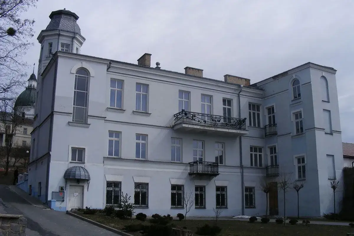 Jasnoniebieski pałac Kretzschmar&oacute;w w Chełmie z wieżyczką i balkonami.