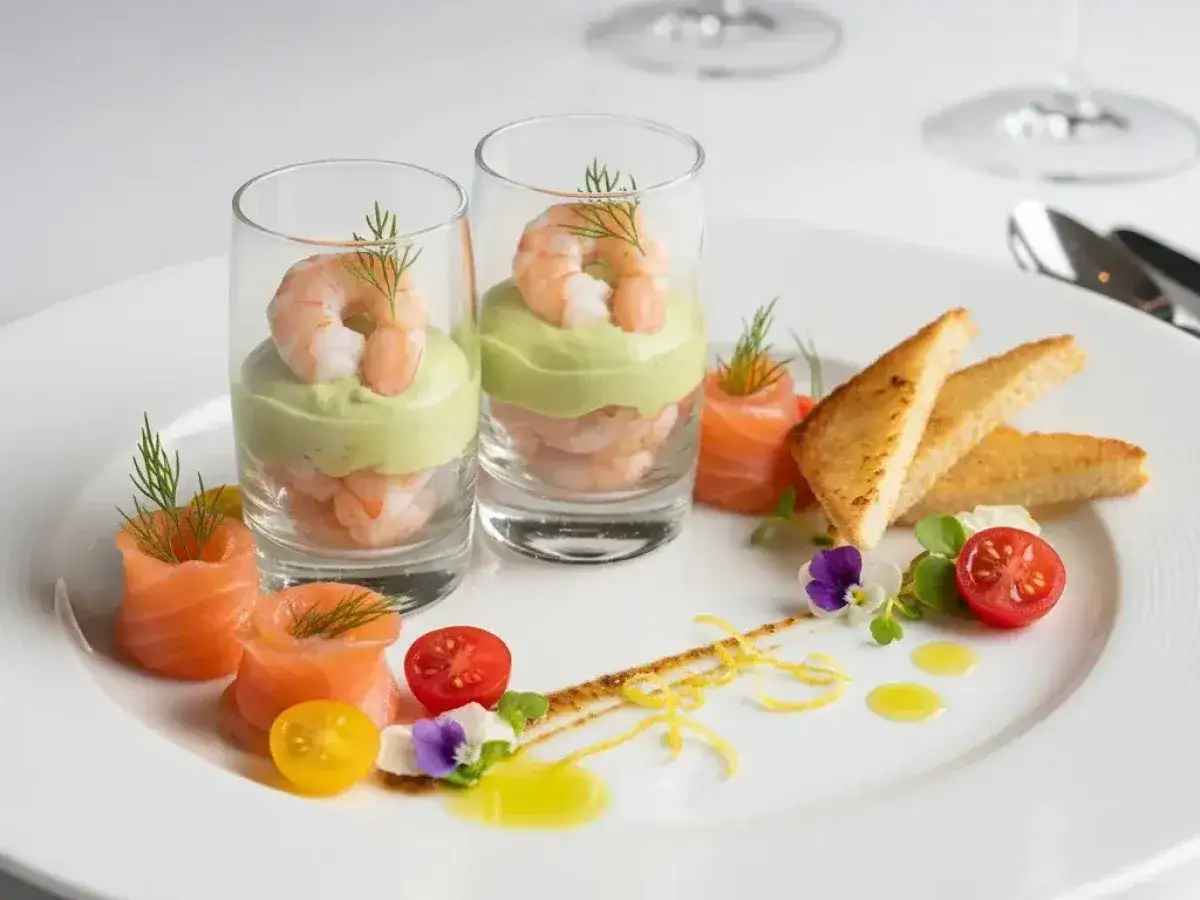 Une d&eacute;licieuse entr&eacute;e froide : crevettes et avocat en verrine, saumon fum&eacute; en rosace, toasts grill&eacute;s, tomates cerises et fleurs comestibles.