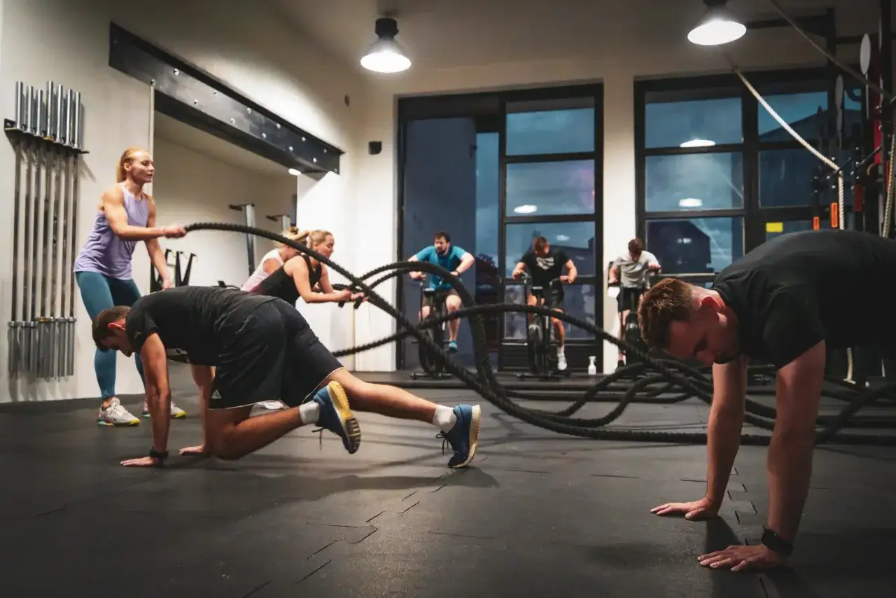 Trening CrossFit w boxie, ludzie ćwiczący, trener