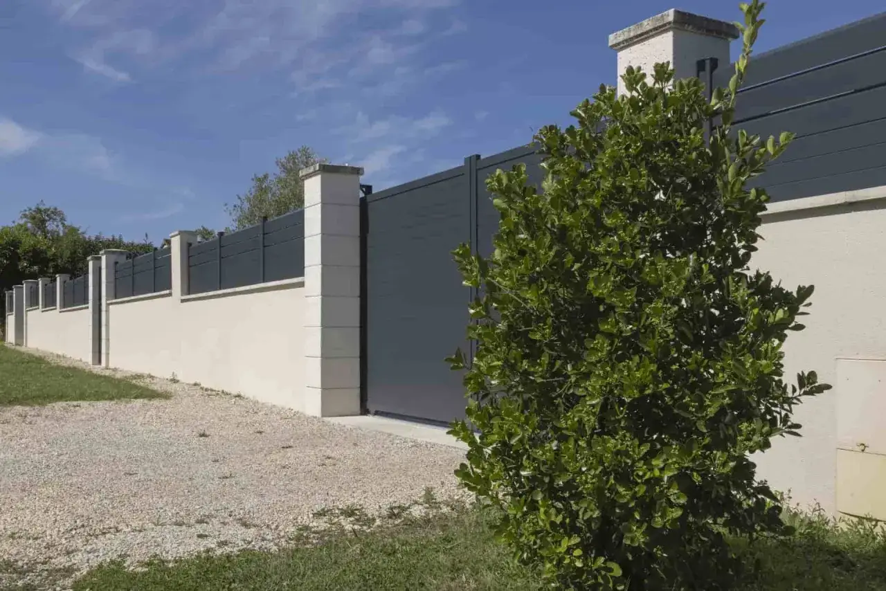 Une nouvelle clôture moderne remplace une ancienne haie de thuyas, offrant une esthétique épurée et une sécurité accrue.