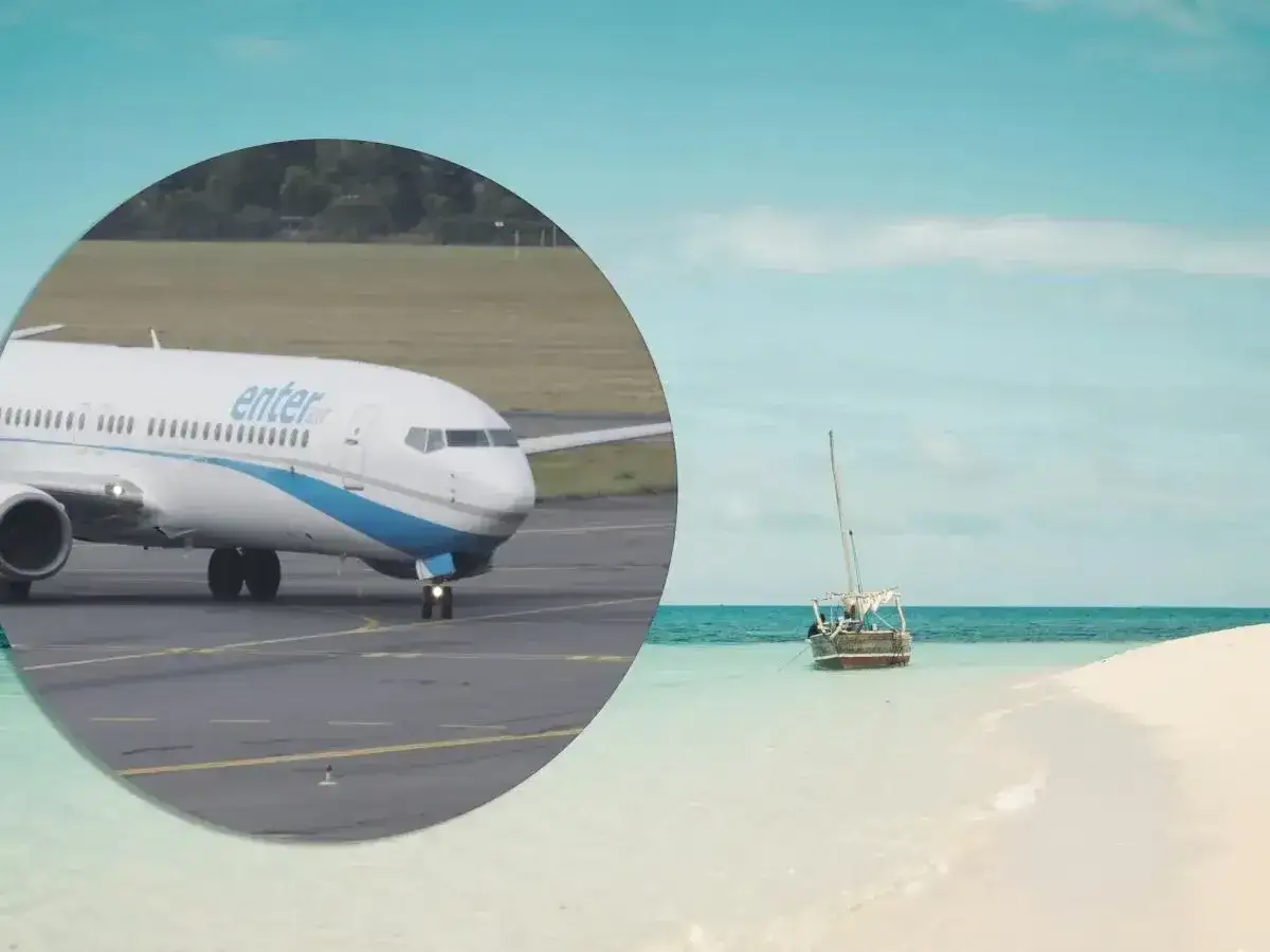 Samolot Enter Air na płycie lotniska, obok rajskiej plaży z łodzią. Dowiedz się, zanzibar ile trwa lot bezpośredni.