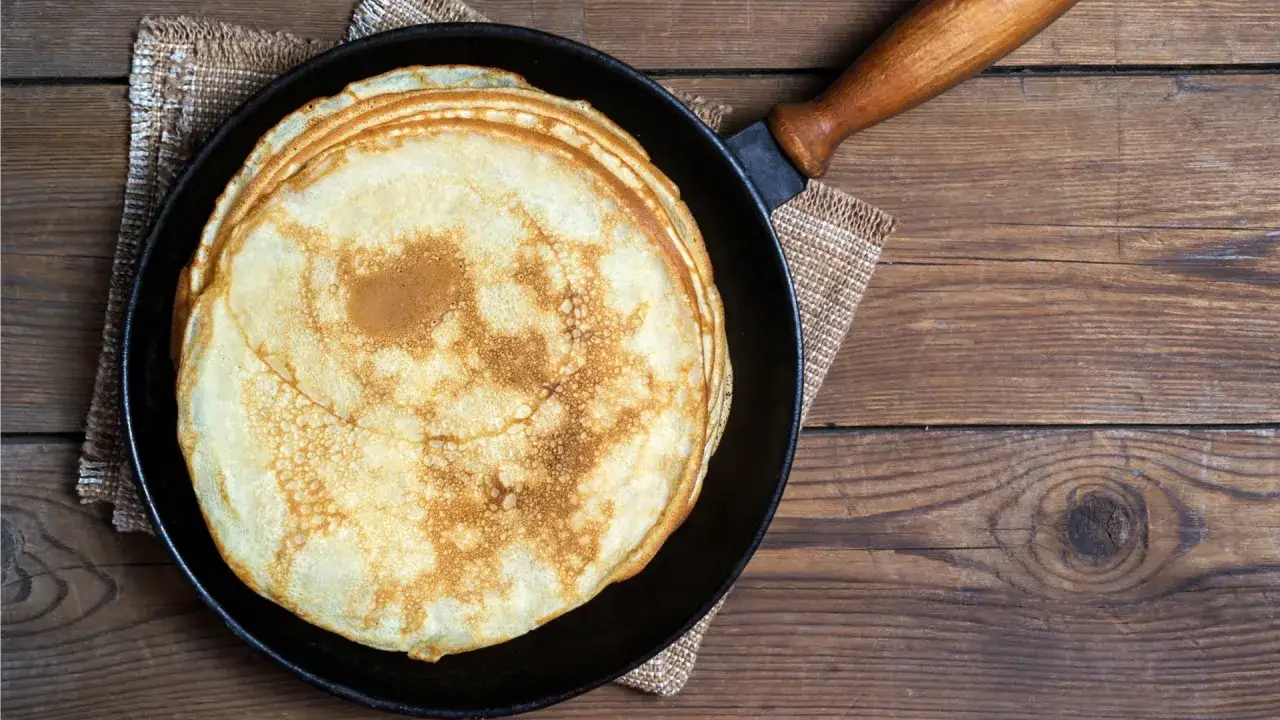 Stos świeżo usmażonych naleśników na patelni, gotowych do podania. Idealny przepis na pancake dla każdego.