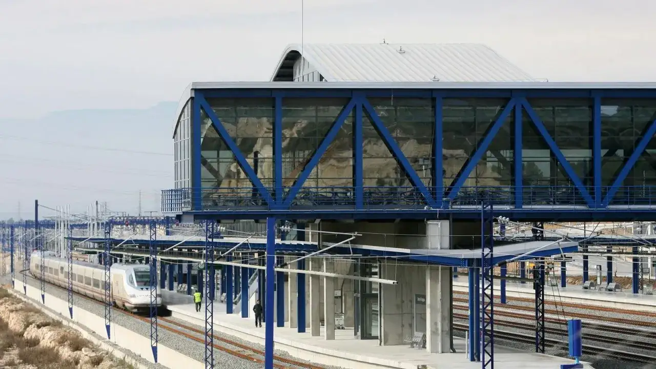 Tren de alta velocidad en la estación de Valencia-Tarragona, con pasarela azul y moderna arquitectura.
