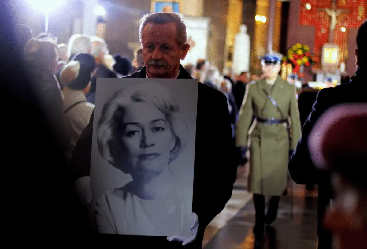 Mężczyzna niesie portret Agaty Boreckiej, córki Aliny Janowskiej, podczas uroczystości.