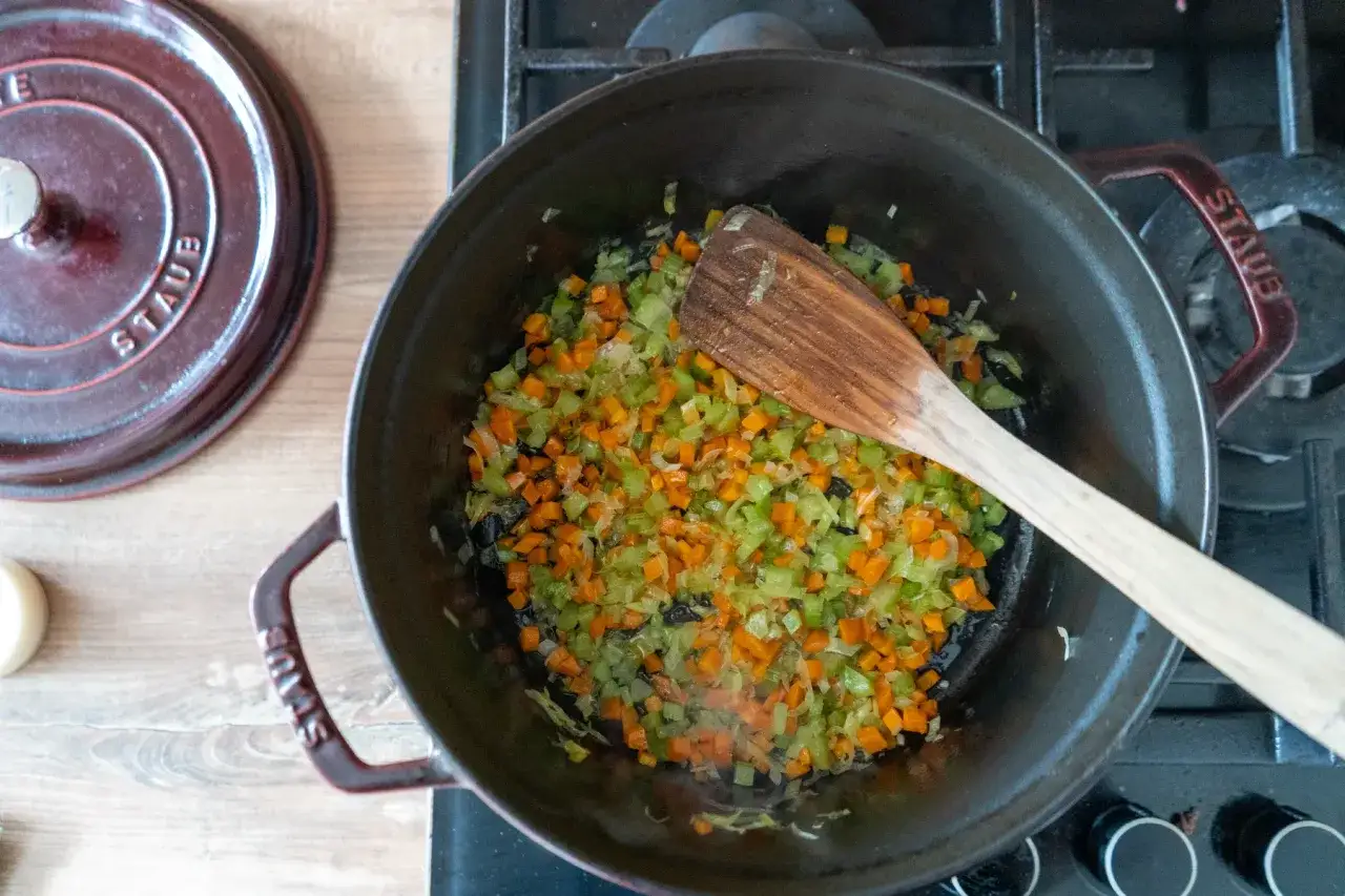 Gemüse für ein Spaghetti Bolognese Rezept wird in einem Topf angebraten.