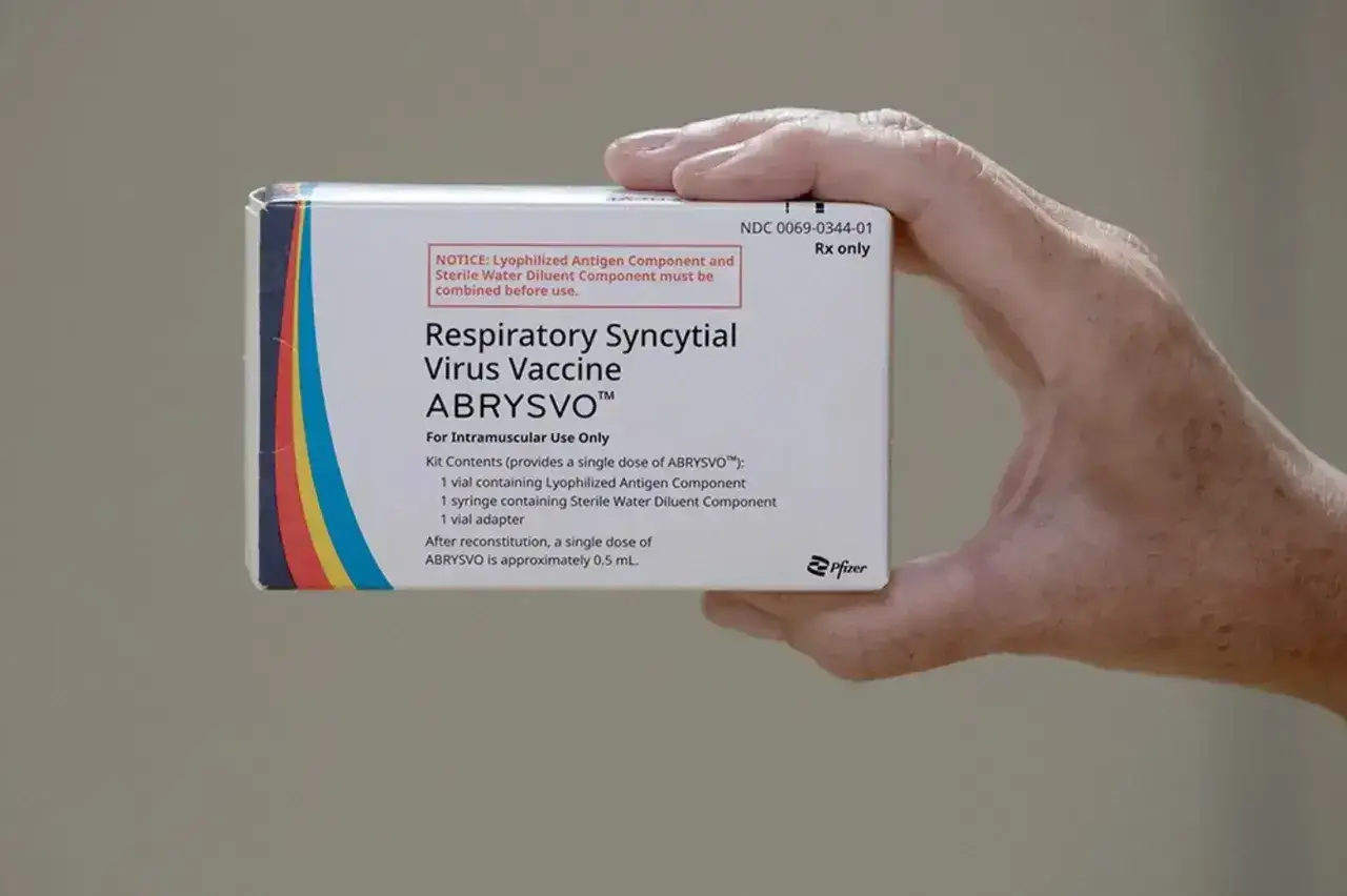Dłoń trzyma pudełko szczepionki ABRYSVO™ przeciw wirusowi RSV.