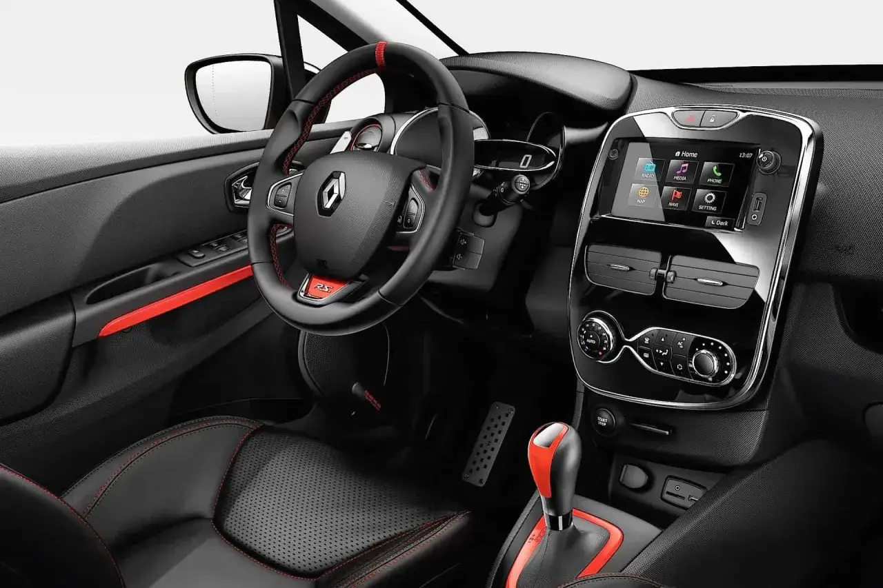 Wnętrze sportowego Clio 4 RS z czarną skórzaną tapicerką, czerwonymi przeszyciami i akcentami. Kierownica z logo RS.