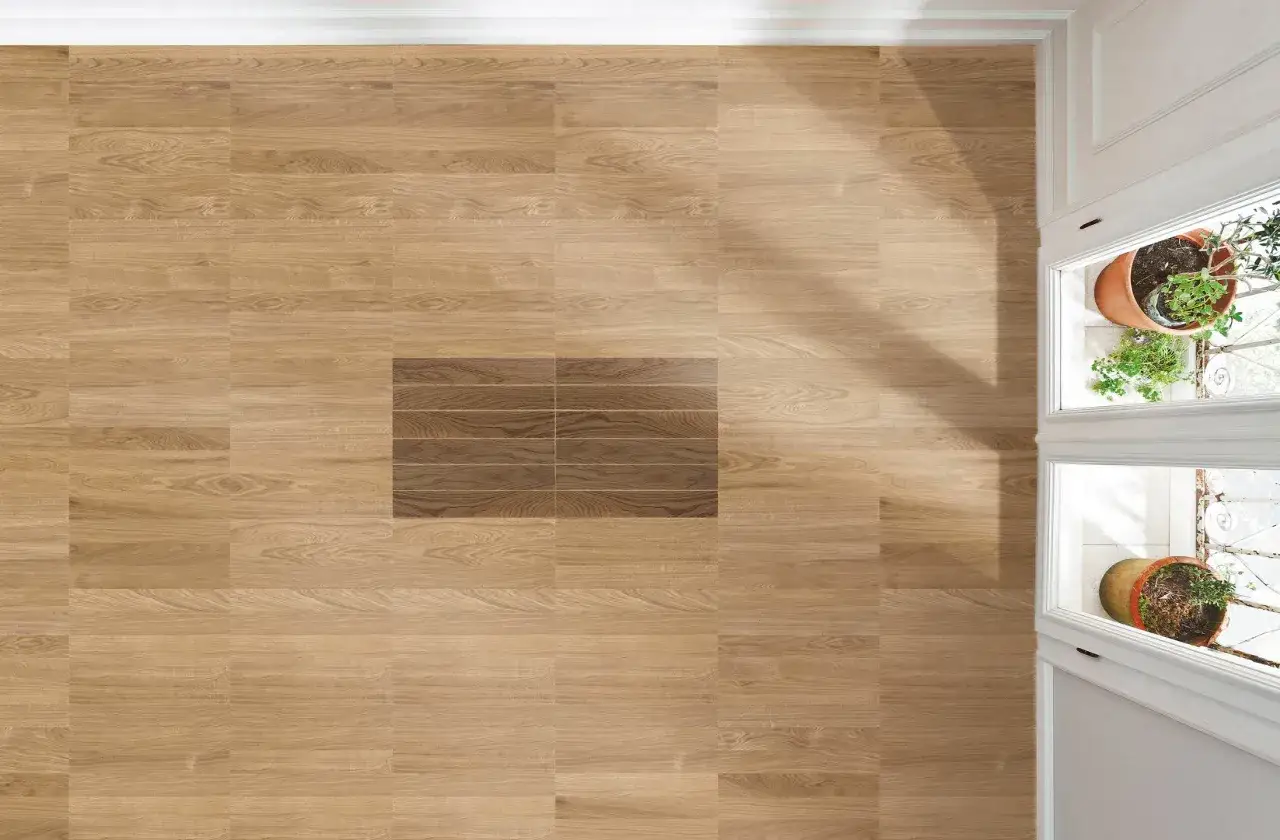 Un pavimento in legno chiaro con un inserto di listelli più scuri, che mostra diversi tipi di parquet.