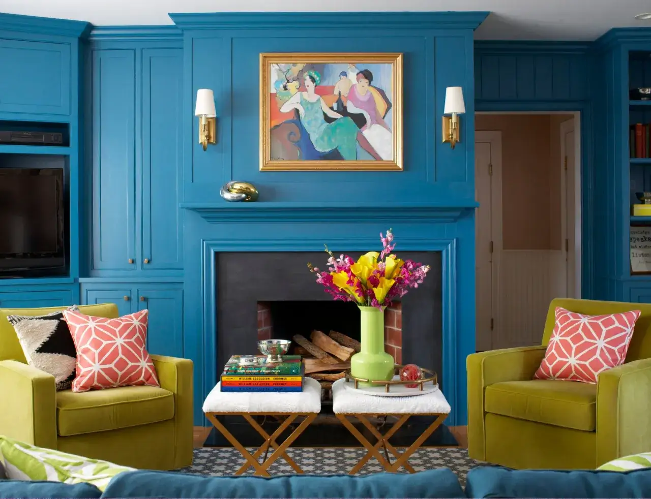 Ein Wohnzimmer mit blauen Wänden, gelben Sesseln und einem bunten Blumenstrauß. Helle Farben dominieren das Bild.