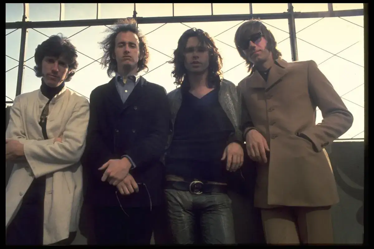Członkowie The Doors pozują do zdjęcia na tle kratownicy.