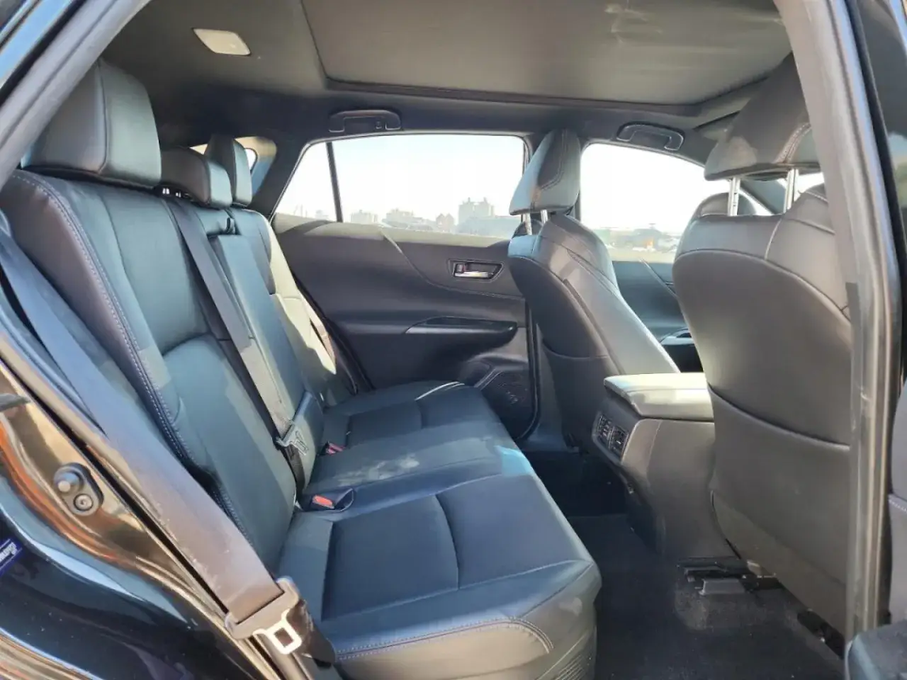 Wnętrze Toyoty Venza: czarne, skórzane siedzenia, panoramiczny dach i przestronna kanapa. Idealne na rodzinne podróże.
