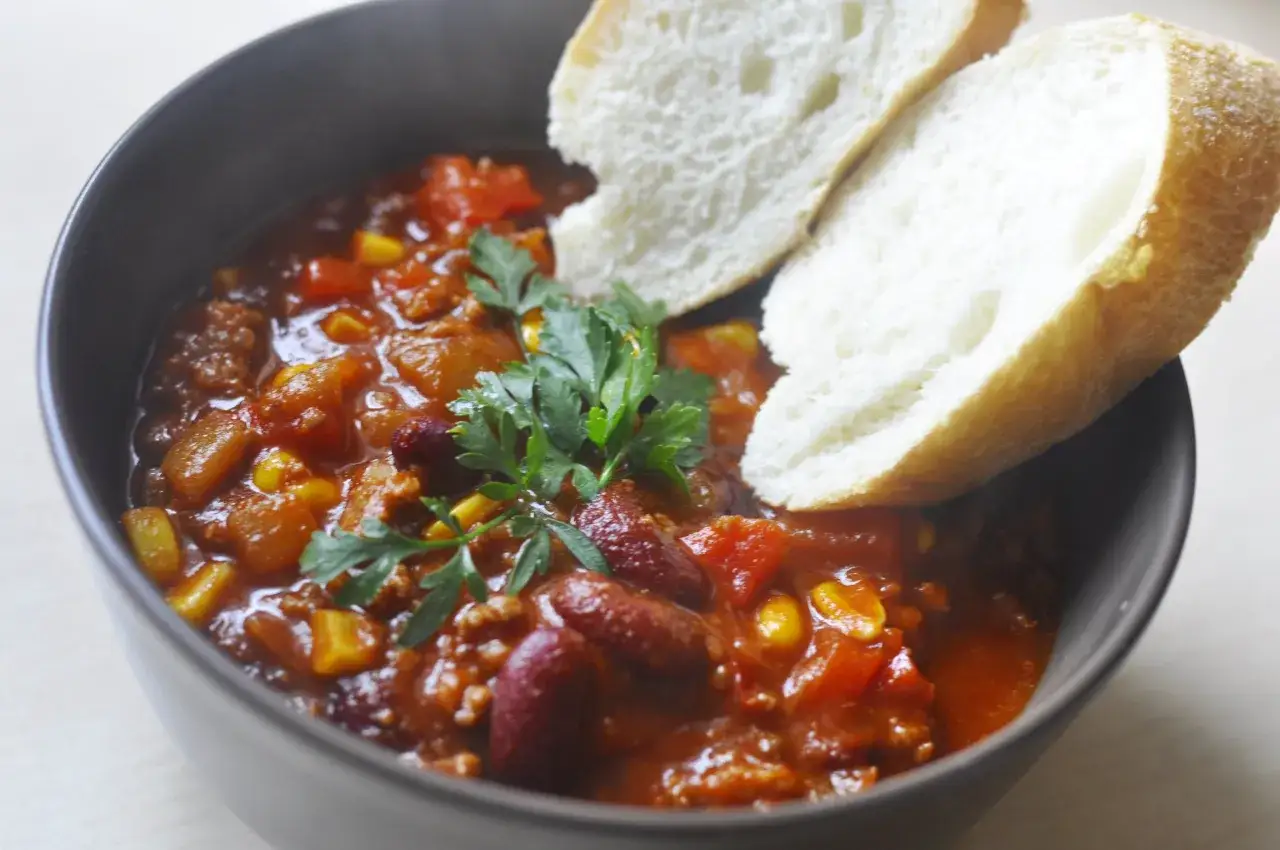 Gęste, aromatyczne chilli con carne z fasolką i kukurydzą, podane z chrupiącym pieczywem. Idealne na chłodne dni.