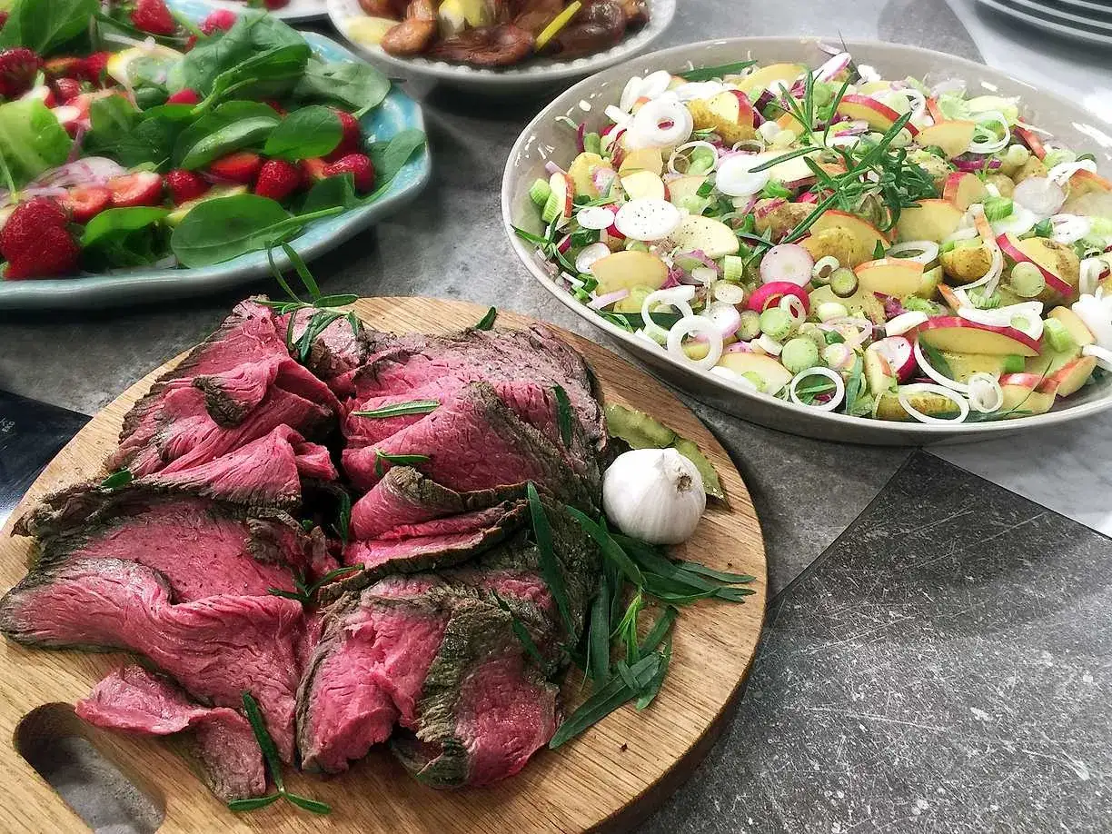 Skivad rostbiff, perfekt för ett somrigt recept. Serveras med en fräsch potatis- och äppelsallad samt en grönsallad med jordgubbar.
