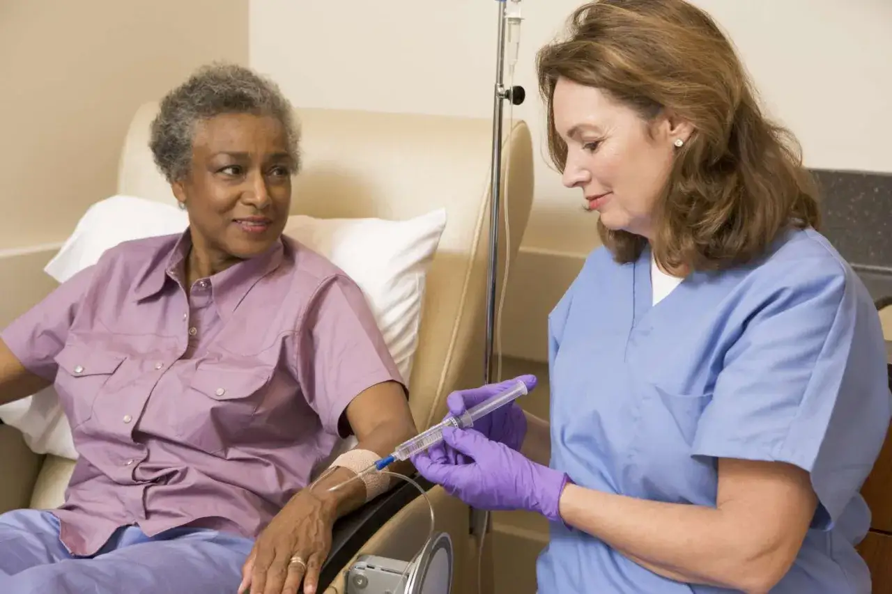 Pflegekraft verabreicht adjuvante Chemotherapie per Infusion an eine Patientin.