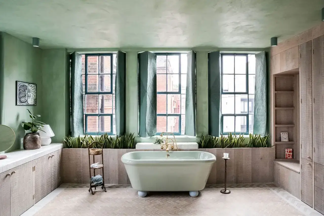 Bagno con vasca verde menta, piante rigogliose e un suggestivo bagno soffitto colorato che crea un'atmosfera rilassante.
