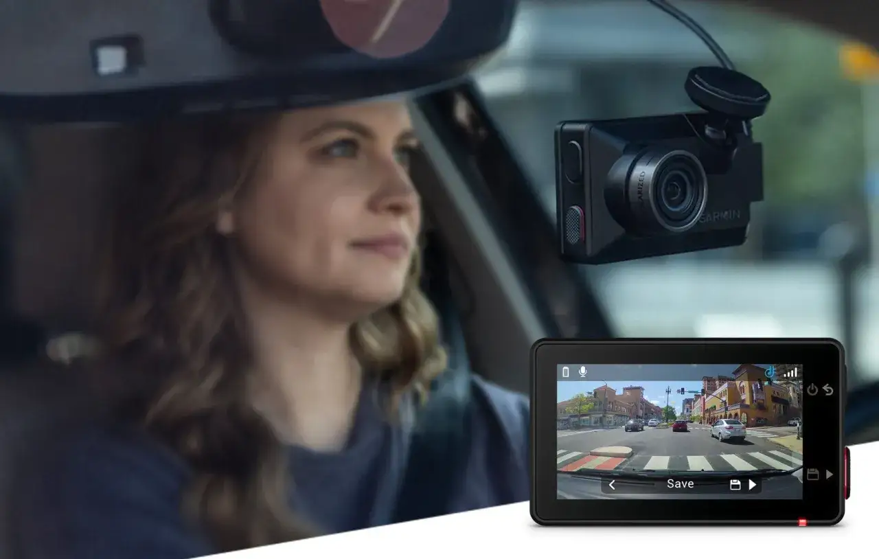 Kobieta jedzie samochodem, a wideorejestrator Garmin nagrywa drogę w Czechach. Na ekranie widać ulicę z budynkami i innymi pojazdami.