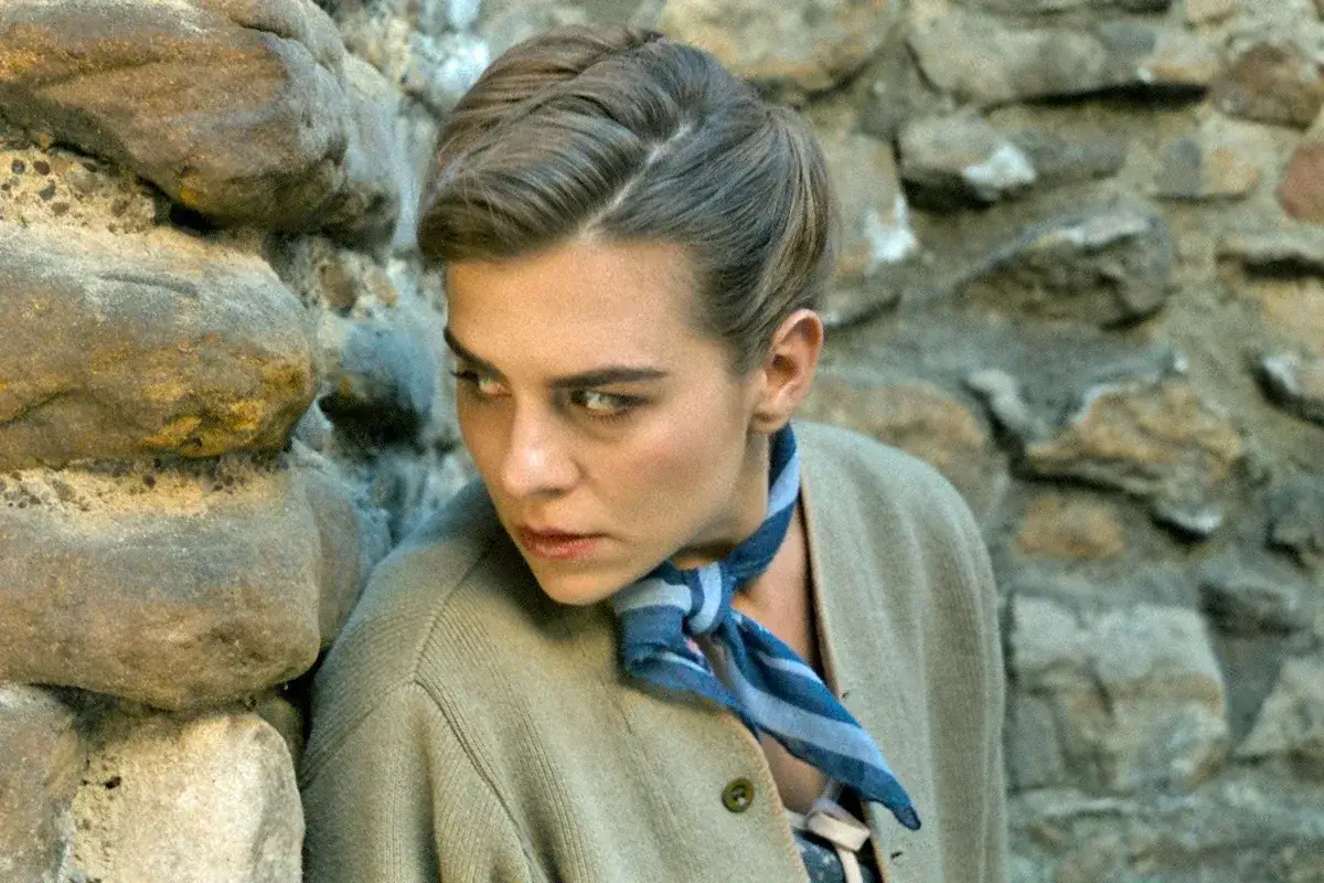 Kobieta w stylu retro, przypominająca Krystynę Skarbek, w scenie z filmu.