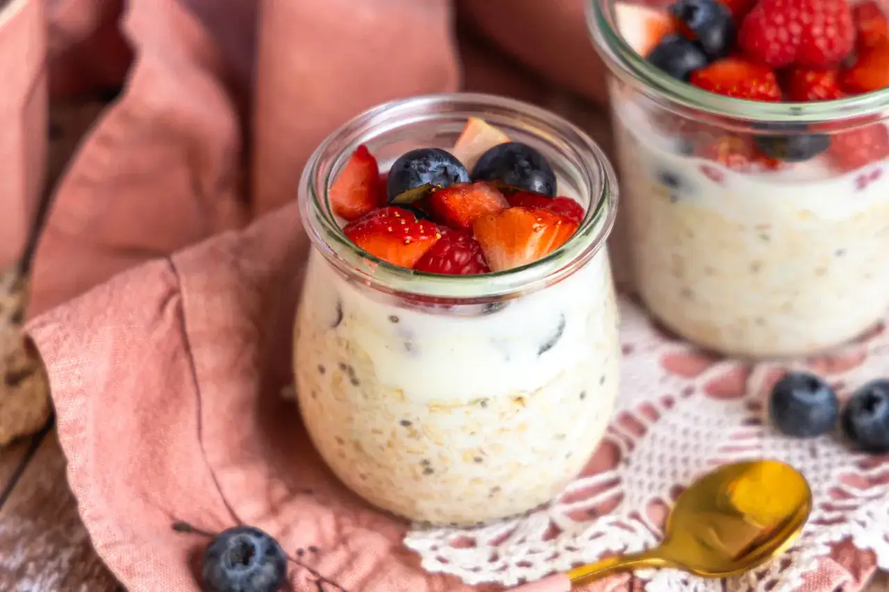 Overnight oats mit Joghurt und frischen Beeren in Gläsern, ein leckeres und gesundes Frühstück.