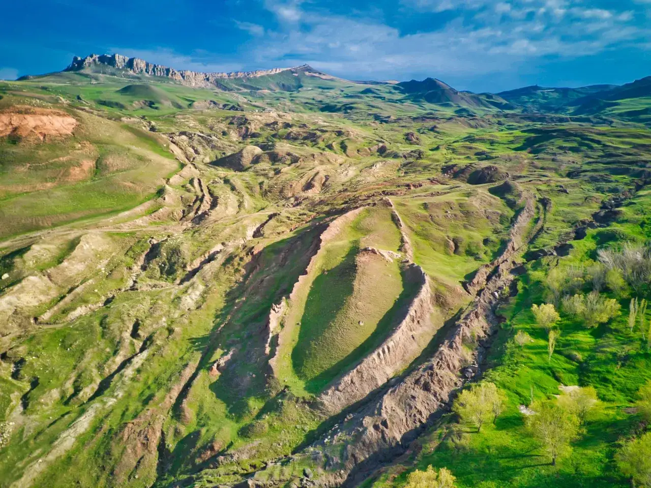 Gröna, böljande kullar med dramatiska raviner och en bergskedja i bakgrunden. Det ser ut som en plats där Noaks ark landade, en vild och orörd natur.