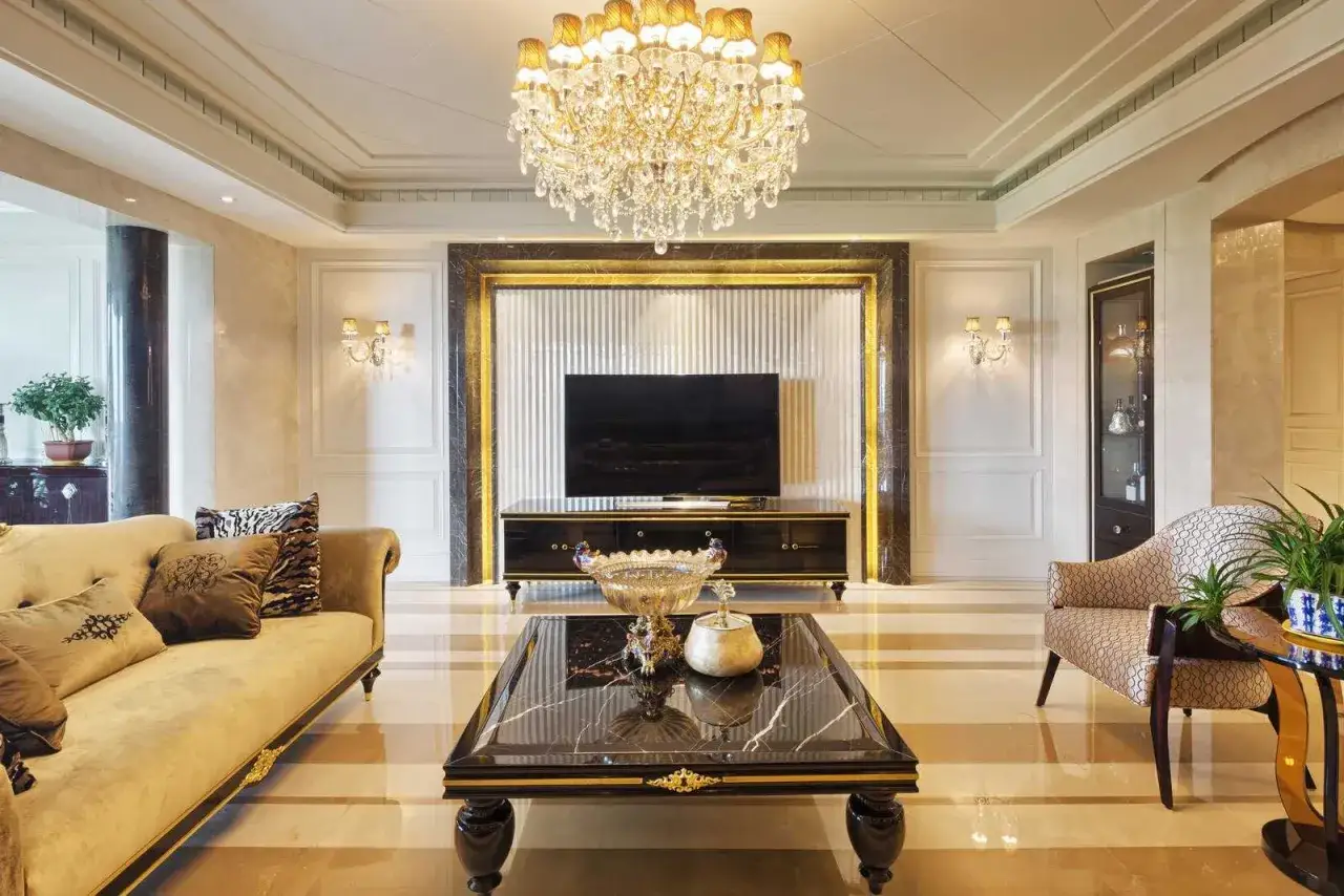 Eleganckie mieszkanie w stylu glamour. Złoty żyrandol, marmurowy stolik i luksusowa sofa tworzą wyrafinowaną atmosferę.