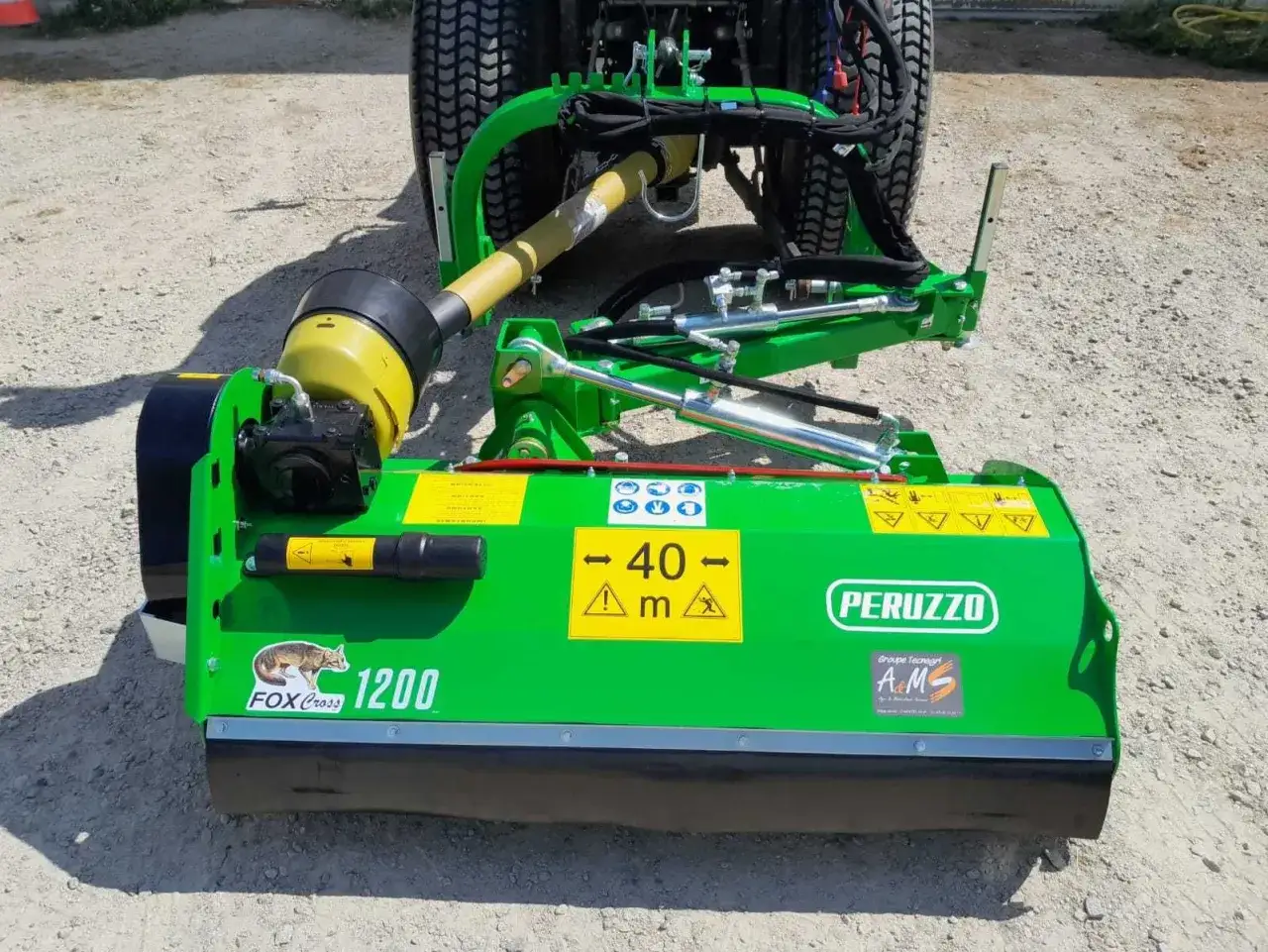 Zielona kosiarka bijakowa boczna Peruzzo FOX Cross 1200 z wałem napędowym, gotowa do pracy na polu.