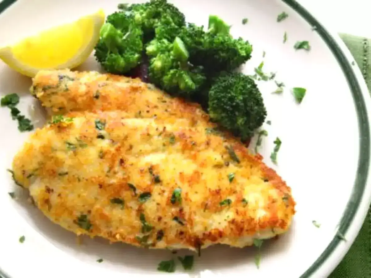 Due cotolette al forno dorate e croccanti, servite con broccoli al vapore e una fetta di limone.