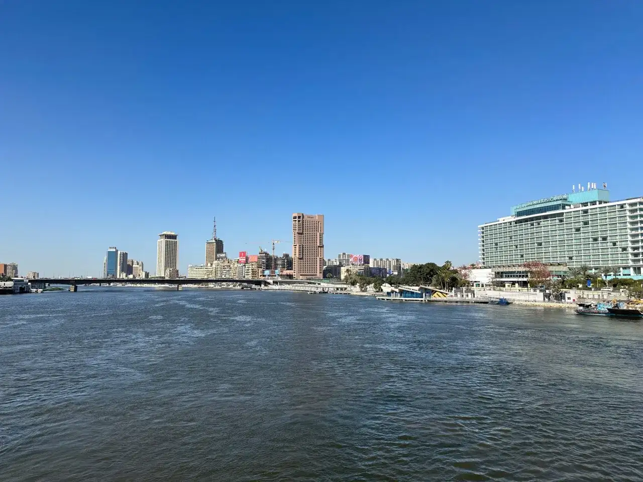 Widok na Nil i nowoczesną panoramę Kairu, stolicy Egiptu, z mostem i budynkami hotelowymi.