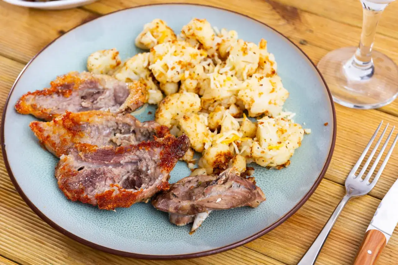 D&eacute;licieux morceaux de gigot d'agneau po&ecirc;l&eacute;s, accompagn&eacute;s de chou-fleur r&ocirc;ti et de fromage r&acirc;p&eacute;. Une id&eacute;e parfaite pour savoir que faire avec des morceaux de gigot d'agneau.