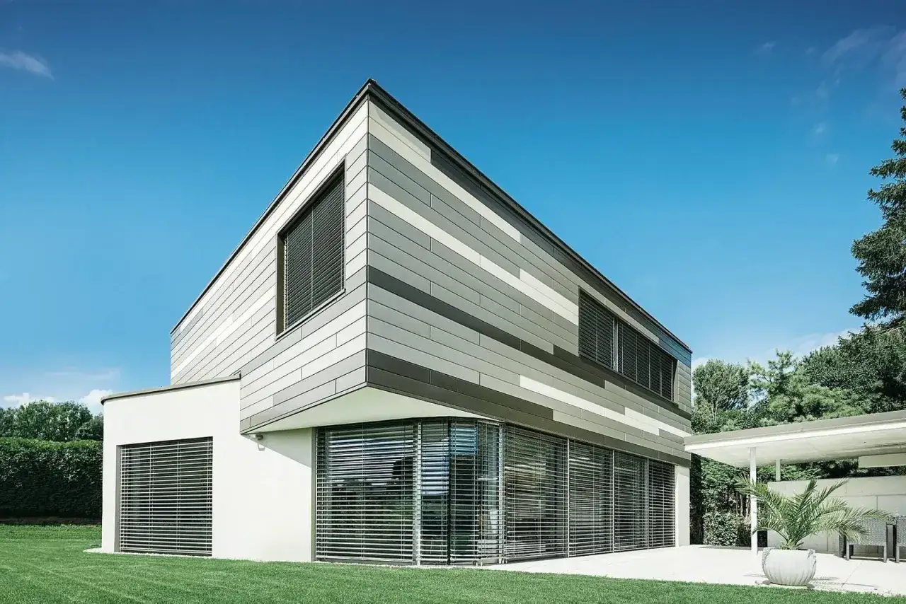 Moderna casa con facciata a listelli grigi e bianchi, un esempio di come scegliere il miglior intonaco per esterni per un design contemporaneo.