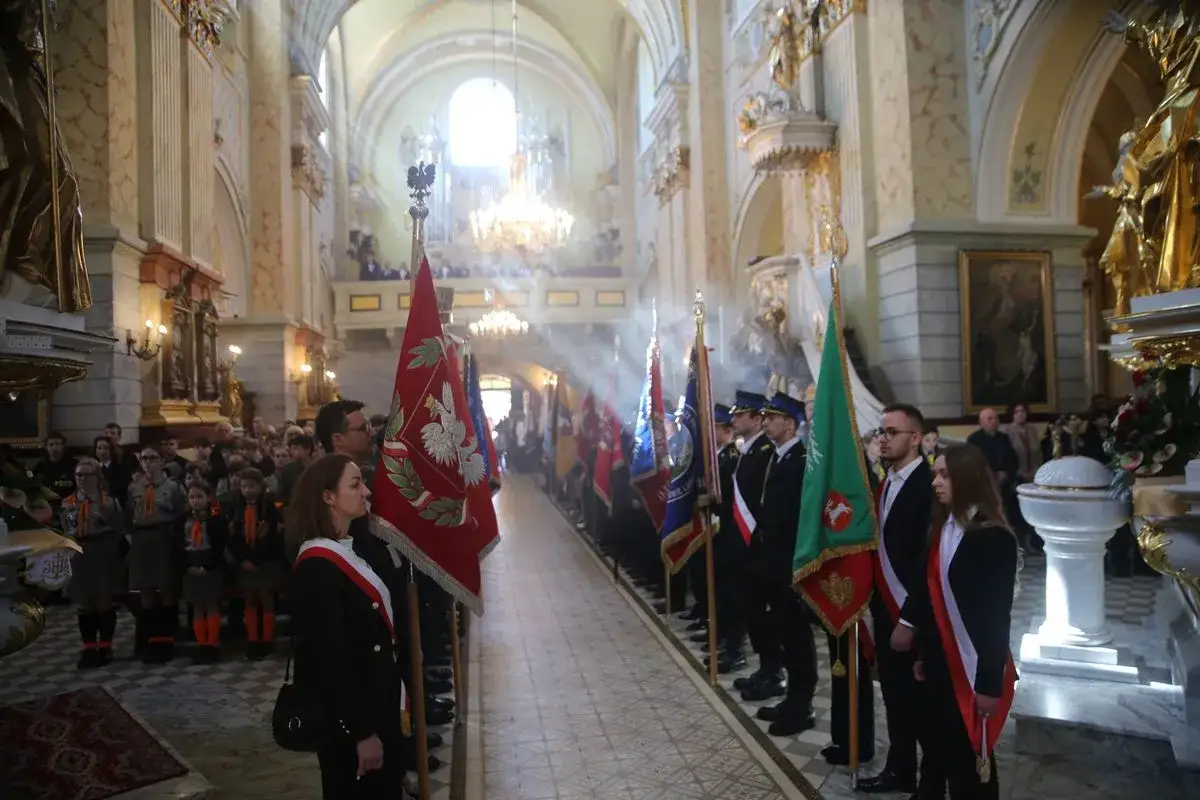 Uroczysta modlitwa za ojczyznę w kościele. Młodzież i harcerze niosą sztandary, tworząc uroczysty poch&oacute;d.
