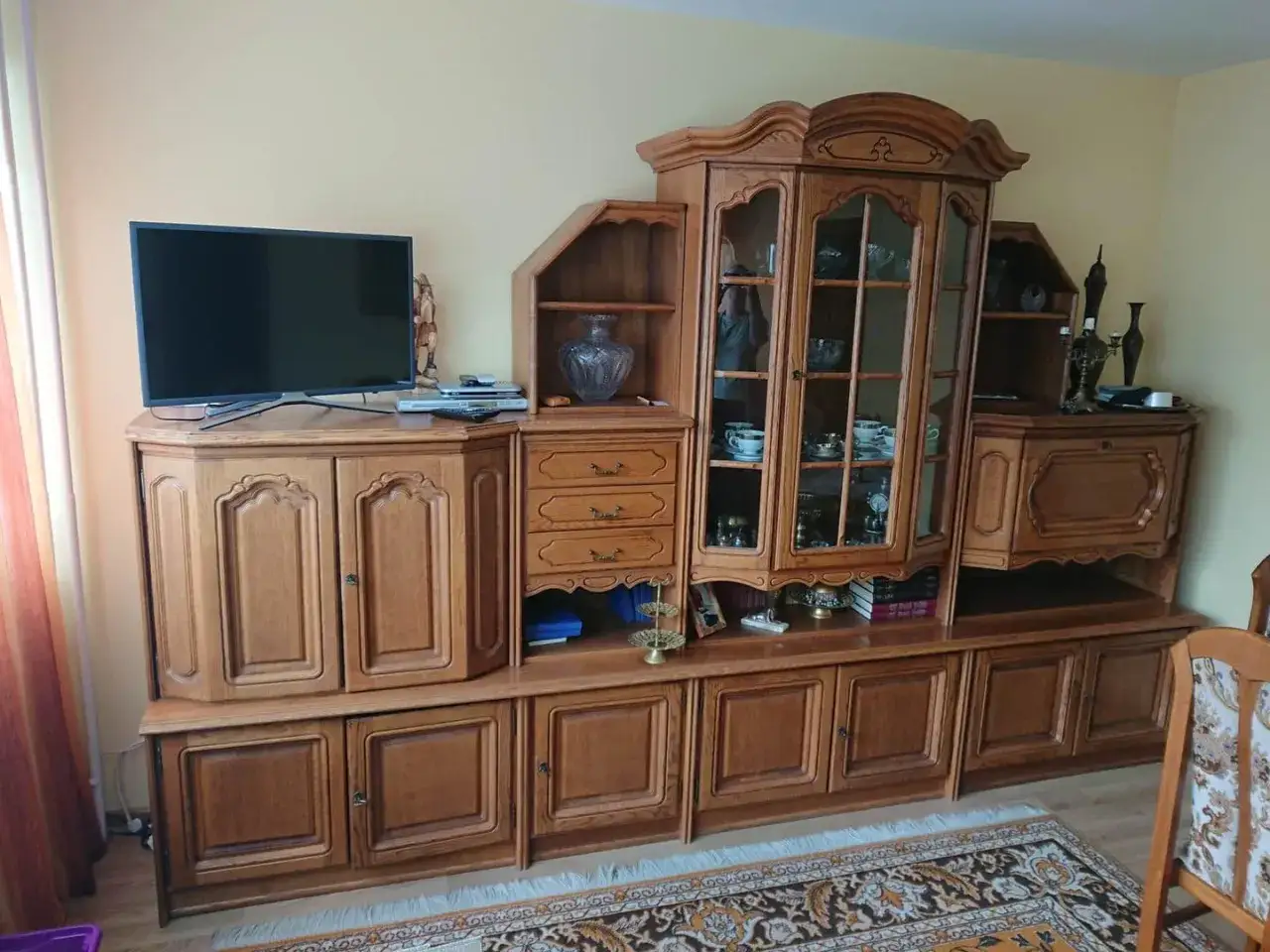 Drewniana meblościanka z przeszkloną witryną i szufladami. Świetne pomysły na odnawianie starych mebli, by nadać im nowy blask.