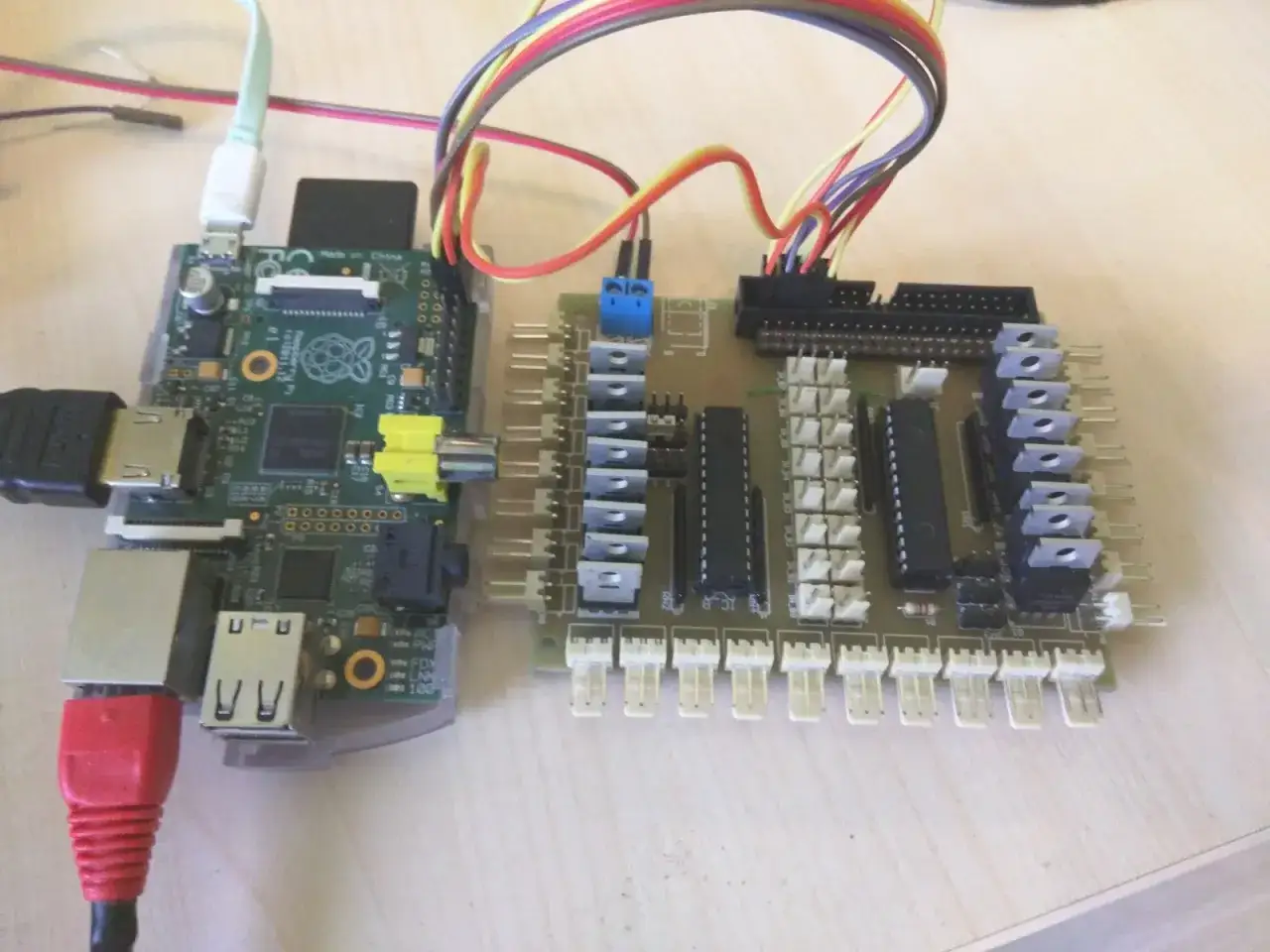 Raspberry Pi podłączony do płytki rozszerzeń z licznymi złączami i układami scalonymi, gotowy do sterowania przez **gpio**.