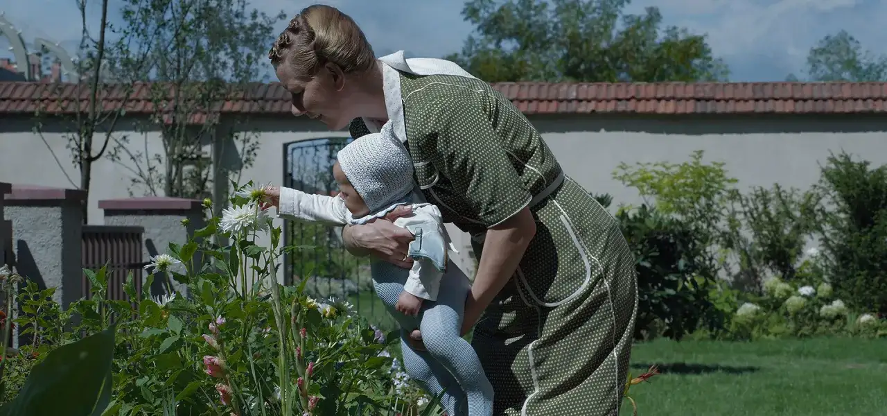 Matka z dzieckiem w ogrodzie, odkrywają piękno kwiatów. Scena z filmu
