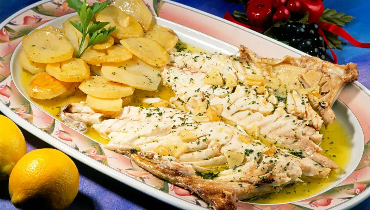 Besugo al horno jugoso, acompañado de patatas panadera y un toque de perejil fresco. ¡Un plato delicioso!