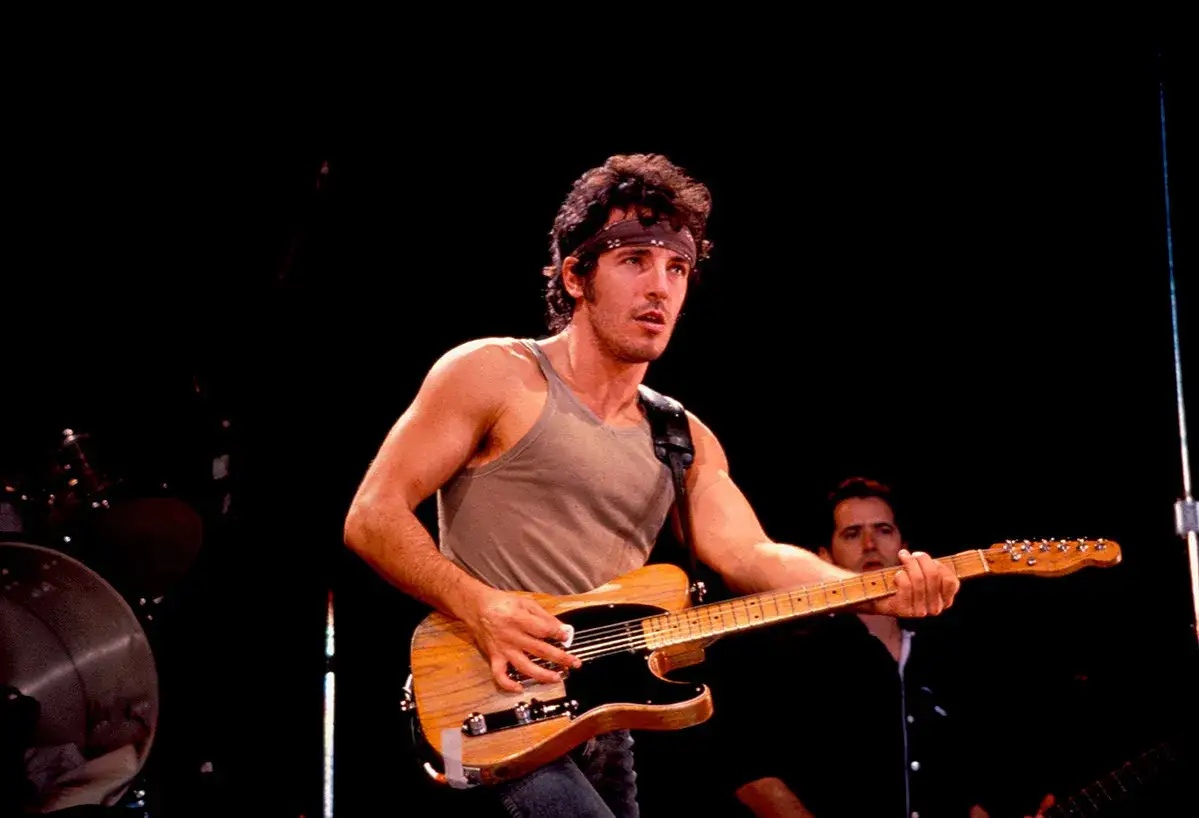 Bruce Springsteen spielt auf seiner ikonischen Gitarre, ein Bild voller Energie und Leidenschaft.