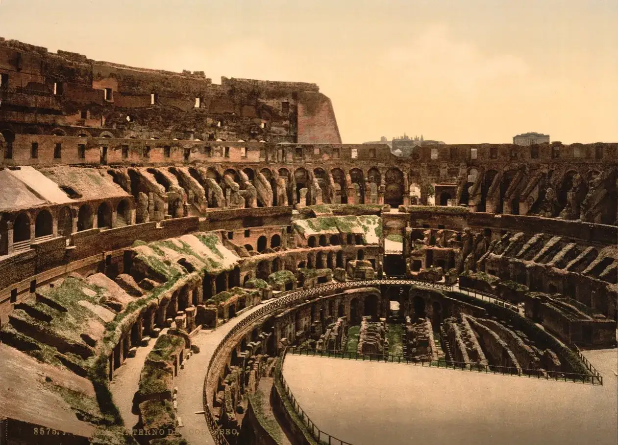 Vista interior del **Coliseo Romano**, con sus arcos y gradas en ruinas, evocando la grandeza del pasado.