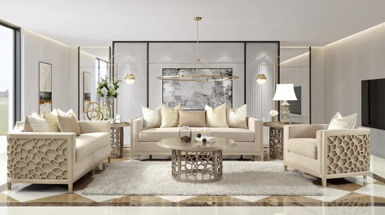 Elegancki salon w odcieniach **kolor szampański**. Miękkie sofy i fotele z ozdobnymi bokami, okrągły stolik kawowy i dywan tworzą przytulną atmosferę.