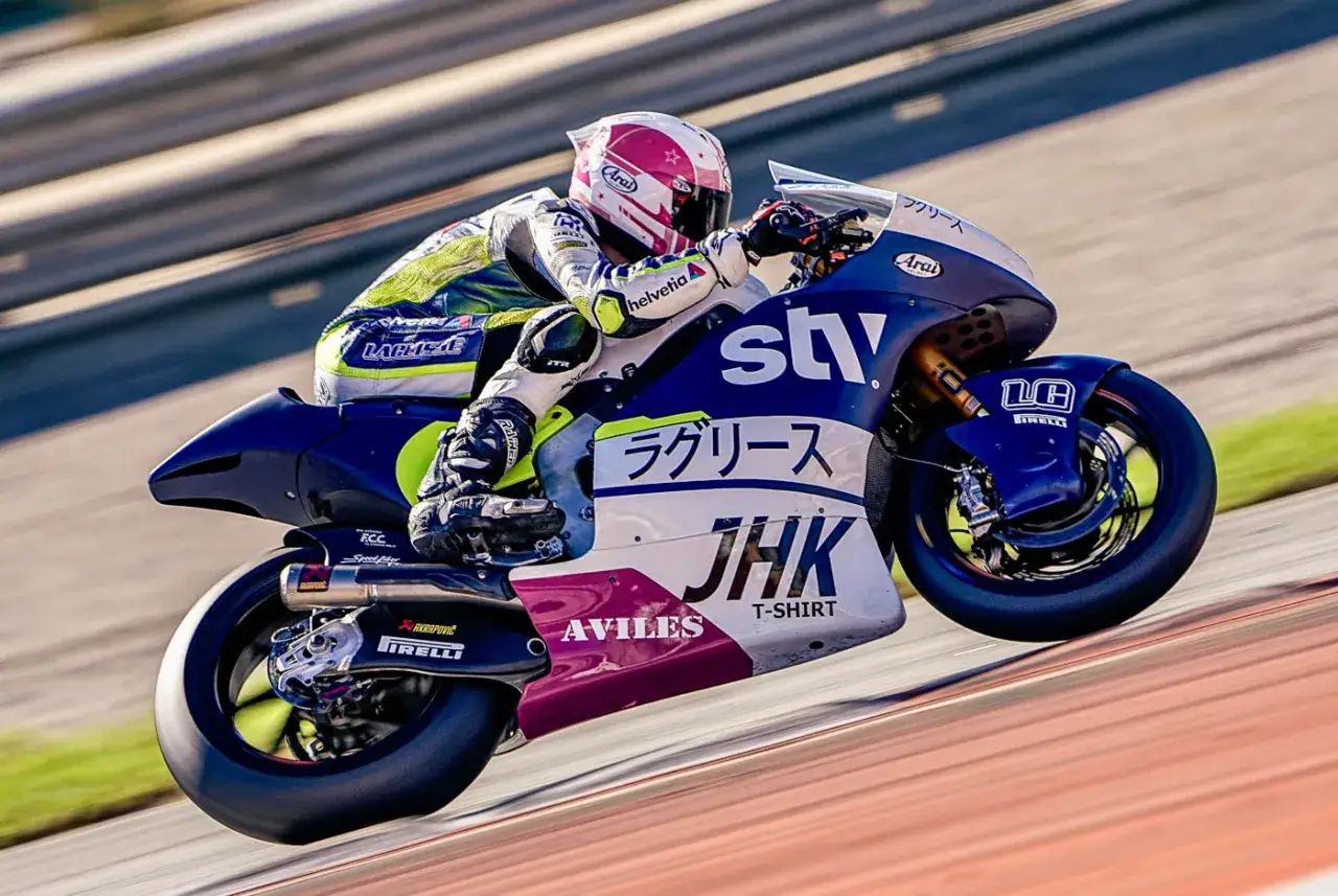 Piotr Biesiekirski w akcji na torze, pochylony na motocyklu z japońskimi napisami.